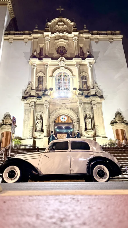 Lateral do Mercedes-Benz 170S 1951 diante da fachada iluminada de uma igreja à noite