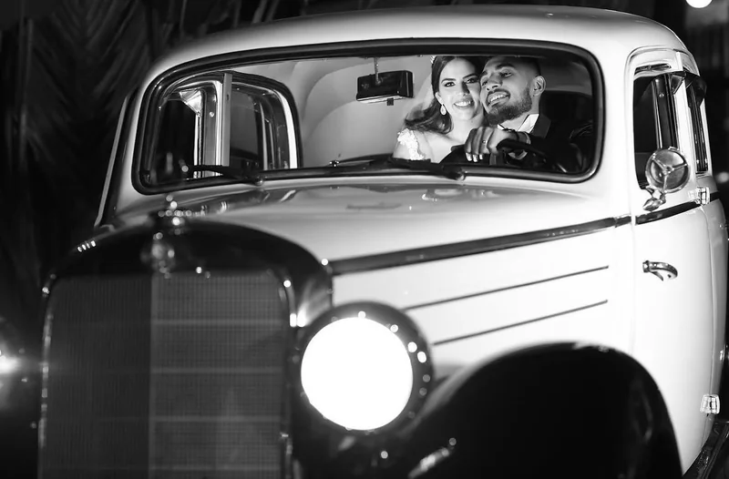 Casal visto pelo para-brisa dentro do Mercedes-Benz 170S, foto em preto e branco com farol em destaque